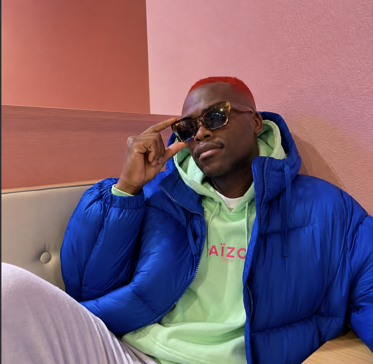 Portrait en hoodie vert Aïzo Paris et doudoune bleue