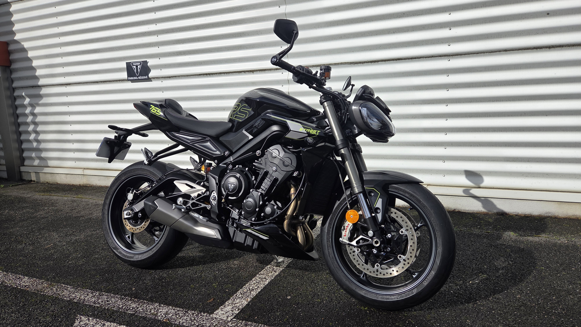 Triumph Street Triple 765 RS 2022 noire devant un bardage métallique